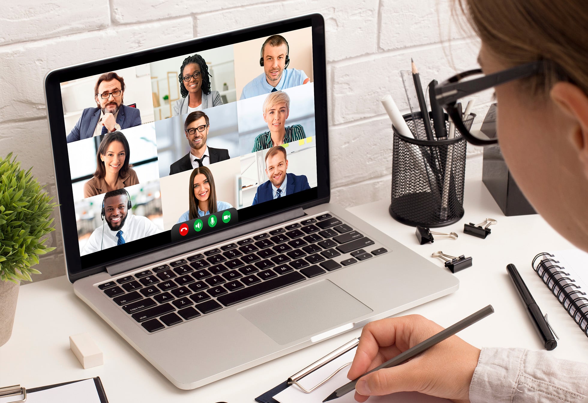 Woman sitting at a desk joining a virtual group meeting.
